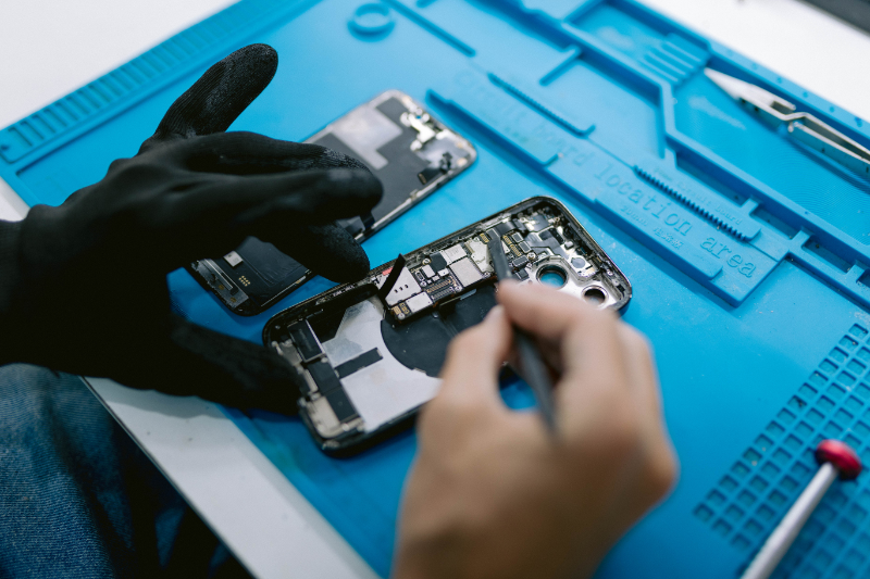 fotografia de un tecnico en dvdconsolas reparando un telefono movil